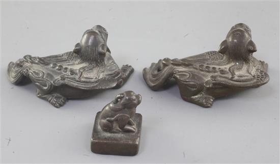 A pair of Chinese bronze mythical beast scroll weights and a similar seal, 18th/19th century, 6.5cm and 3cm